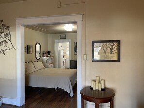 A bedroom with a bed, a dresser, a mirror, and a framed quote on the wall.