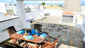 A rooftop terrace with a wooden table set for dining, surrounded by chairs. - Finished house, 100sqm 10 min from the beaches, 500 m from the historic center of Ugento (Ugento)