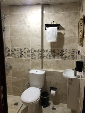 Un baño con inodoro, bidé y lavamanos.