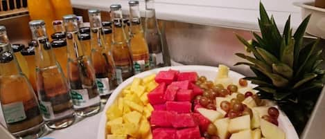 Una mesa de buffet con una variedad de frutas y bebidas.