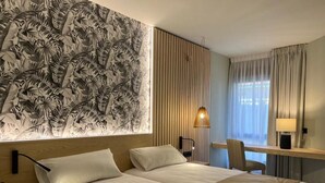 Ein Hotelzimmer mit einem großen Bett, einem Schreibtisch und einem Stuhl.