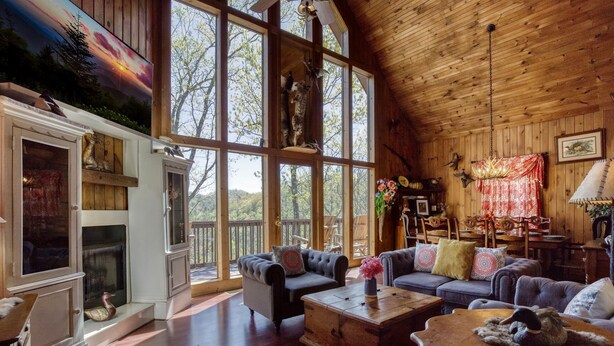 A spacious living room with large windows, a fireplace, and a cozy seating area. - Close to town with private Mountain Setting 3 Bedroom 3 Bathrooom Pet Friendly  Hot tub (Sevierville)