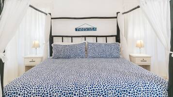 Ein Bett mit Baldachin, zwei Nachttische mit Lampen und ein Schild über dem Bett.