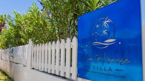 Un letrero azul con el texto 'Seaside Villa' y una dirección web.