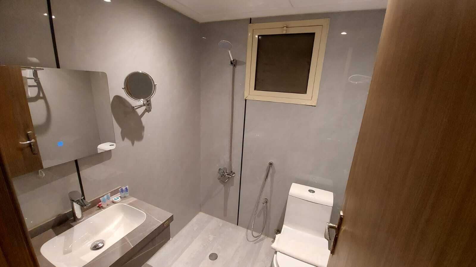 A bathroom with a sink, mirror, shower, and toilet.