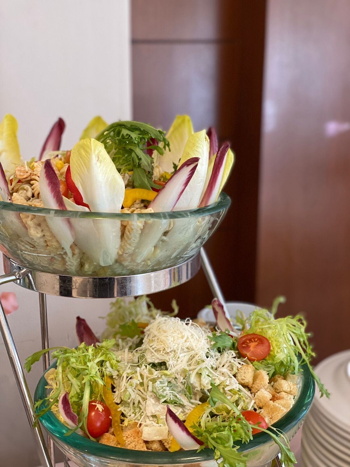 A salad with various vegetables and croutons in a glass bowl.