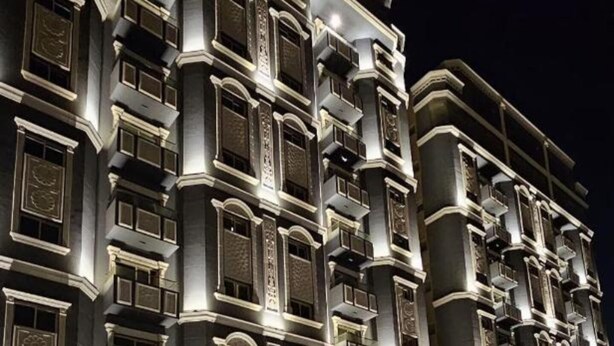 A multi-story hotel with a classic architectural design, featuring balconies and decorative lighting. - Sumou Hotel Al Khobar (Al Khobar)