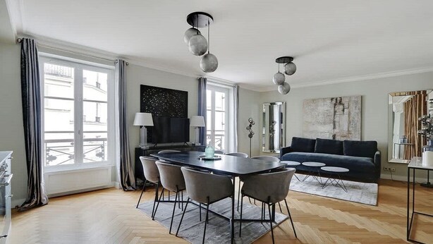 A modern living room with a dining table, sofa, and pendant lights. - Rue Lepic - quintessential winding cobblestone street- Take a step into the past (Paris)