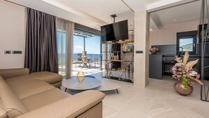 A modern living room with a sofa, a coffee table, and a bookshelf. - villa Aurelia 2-amazing sea and city rooftop view (Makarska)