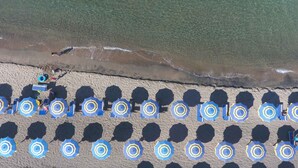 An aerial view of a beach with rows of blue umbrellas and a sandy shoreline. - Mobilehome with air conditioning, terrace and pool (Baia Domizia)