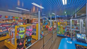 A brightly lit store with various colorful items on shelves and racks, including clothing and accessories. - Mobilehome with air conditioning, terrace and pool (Baia Domizia)