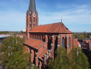A large brick church with a tall tower and a clock.