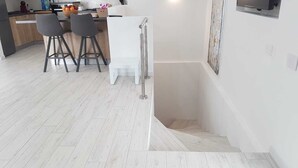 Une cuisine moderne avec un coin repas, agrémentée d’un escalier menant à un niveau supérieur.
