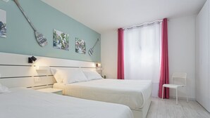 Une chambre avec deux lits, une chaise blanche, une fenêtre avec des rideaux roses et des œuvres d’art murales.