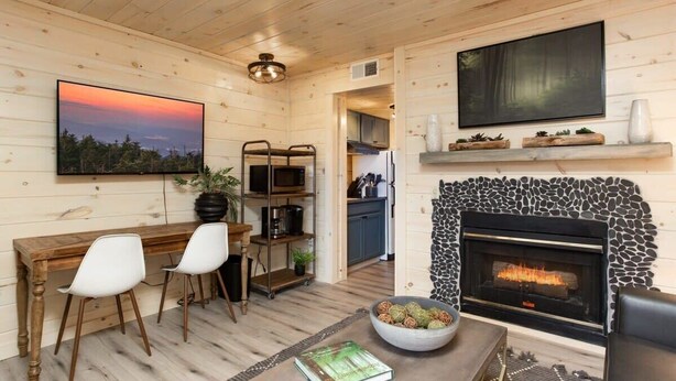Ein gemütliches Blockhaus-Interieur mit Essbereich, Kamin und Küche.