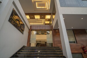 Entrada de un edificio moderno con una escalera que sube a un segundo piso.
