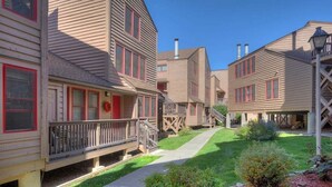 A row of wooden buildings with balconies and a central pathway. - The Passport Suite | Downtown Access, Pool/Hot Tub, Near FLC, Trails & Golf (Durango)