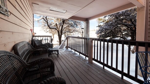 A covered porch with wicker furniture, a railing, and snow on the ground. - The Passport Suite | Downtown Access, Pool/Hot Tub, Near FLC, Trails & Golf (Durango)