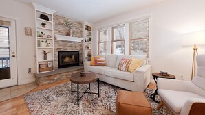 A living room with a fireplace, a sofa, a coffee table, and a lamp. - The Passport Suite | Downtown Access, Pool/Hot Tub, Near FLC, Trails & Golf (Durango)