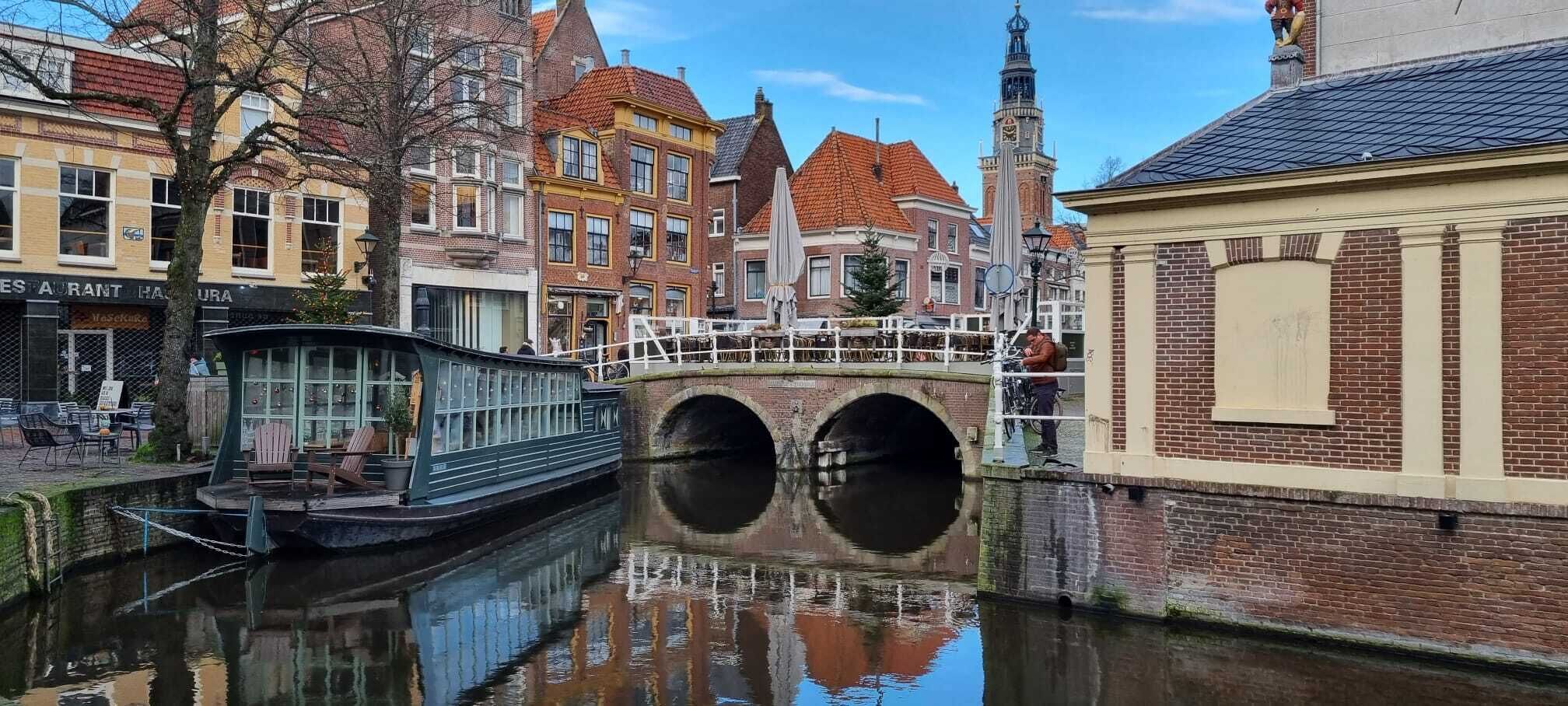 En kanal med en bro, en båd og bygninger med traditionel arkitektur.