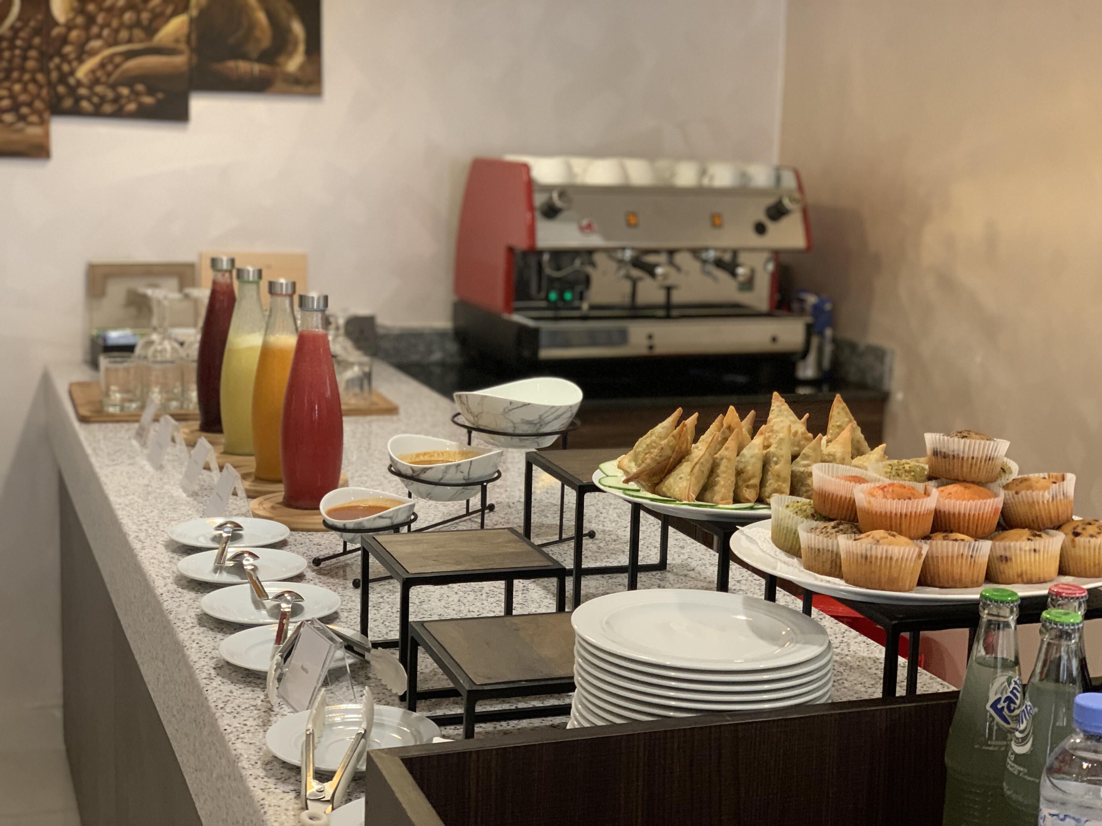 A buffet setup with various food items, plates, and condiments.
