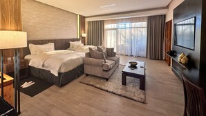 Une chambre d’hôtel avec un grand lit, un canapé, une table basse et un téléviseur.