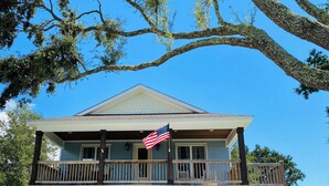 A two-story house with a balcony, an American flag, and the number 116 on the front. - Coastal home walking distance to the beach (Long Beach)