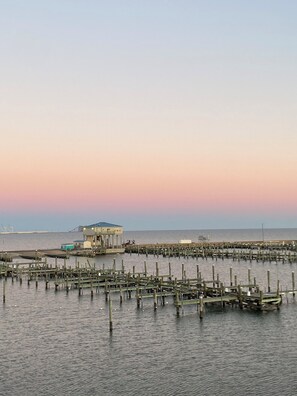 A waterfront pier with a building, wooden structures, and calm water.