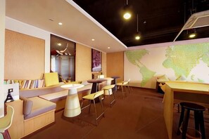 A modern interior with seating areas, tables, and a large wall map. - IU Hotel (Chongqing Hechuan Ruishan Road Ta'ermen Square) (Chongqing)