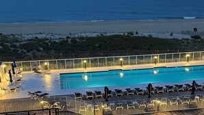 A swimming pool with lounge chairs and a view of the beach. - Direct oceanfront rennovated condo with panoramic views of ocean and bay right on the beach! (Ocean City)