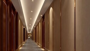 A long, narrow hallway with wooden paneling on both sides and a carpeted floor. - Bojing Hotel (Yuechi)