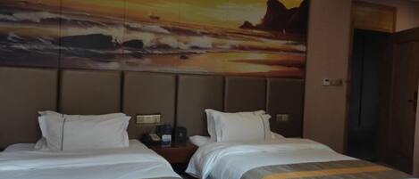 Une chambre d’hôtel avec deux lits, une grande peinture représentant un coucher de soleil sur l’océan accrochée au mur et une porte en bois.
