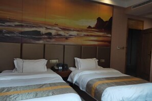 Habitación de hotel con dos camas, un cuadro grande de una puesta de sol sobre el océano en la pared y una puerta de madera.