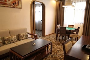 A hotel room with a sofa, a coffee table, a dining table with chairs, and a pool table. - Bojing Hotel (Yuechi)