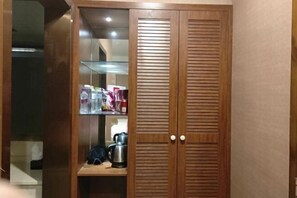Un armario de madera con dos puertas y un estante en su interior.