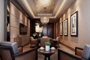 A modern hotel lobby with a dining area, framed artwork on the walls, and a chandelier. - Bojing Hotel (Yuechi)