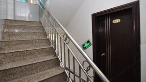 A staircase with granite steps and a metal railing, leading to a dark wooden door marked with the number 301. - Yuxi Jinhua Hotel (Yuxi)