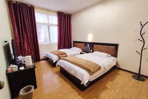 A hotel room with two beds, a desk with a chair, a TV, and a window with curtains. - Yuxi Jinhua Hotel (Yuxi)