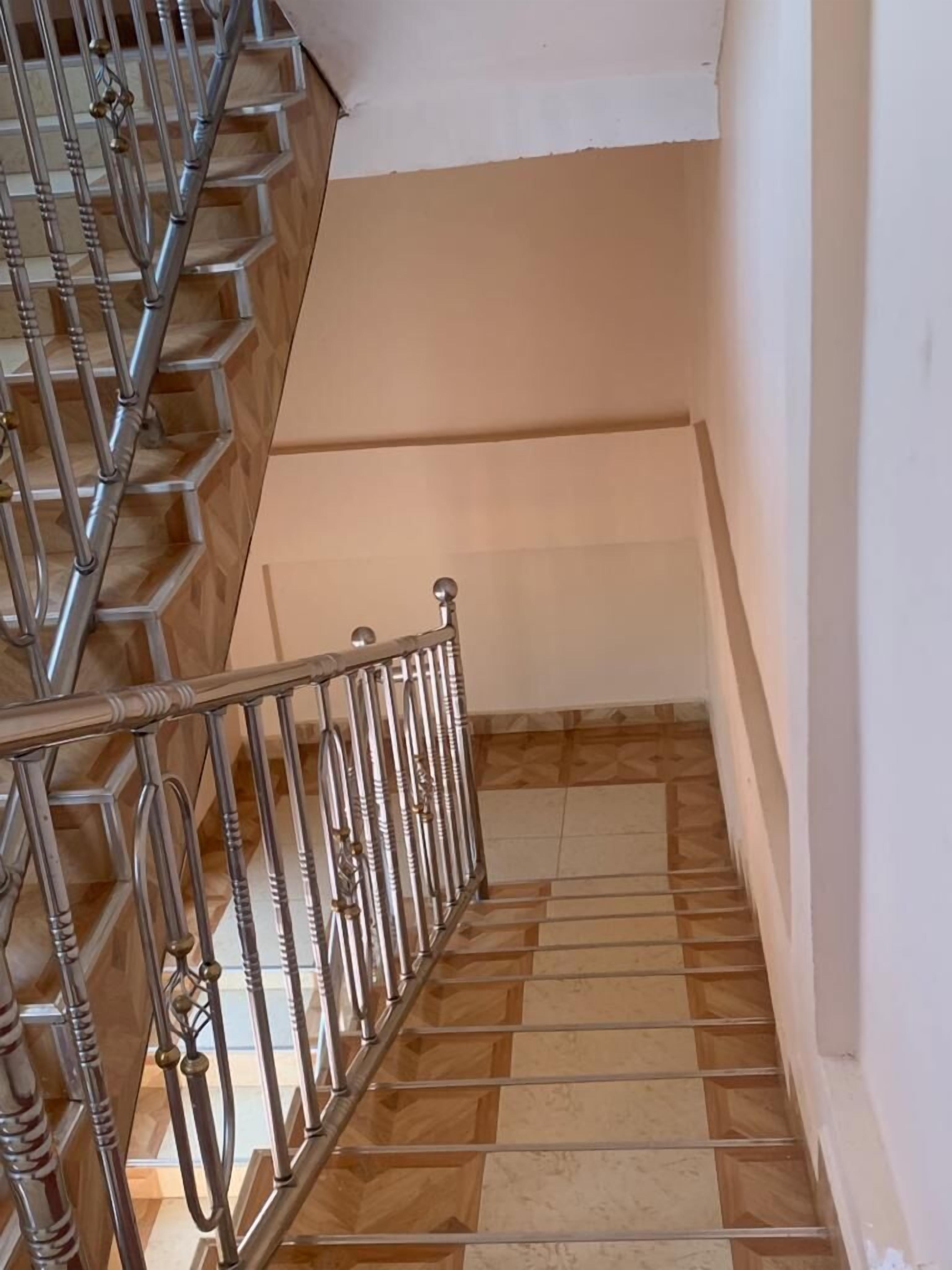 Eine Treppe mit Metallgeländer und Holzstufen.