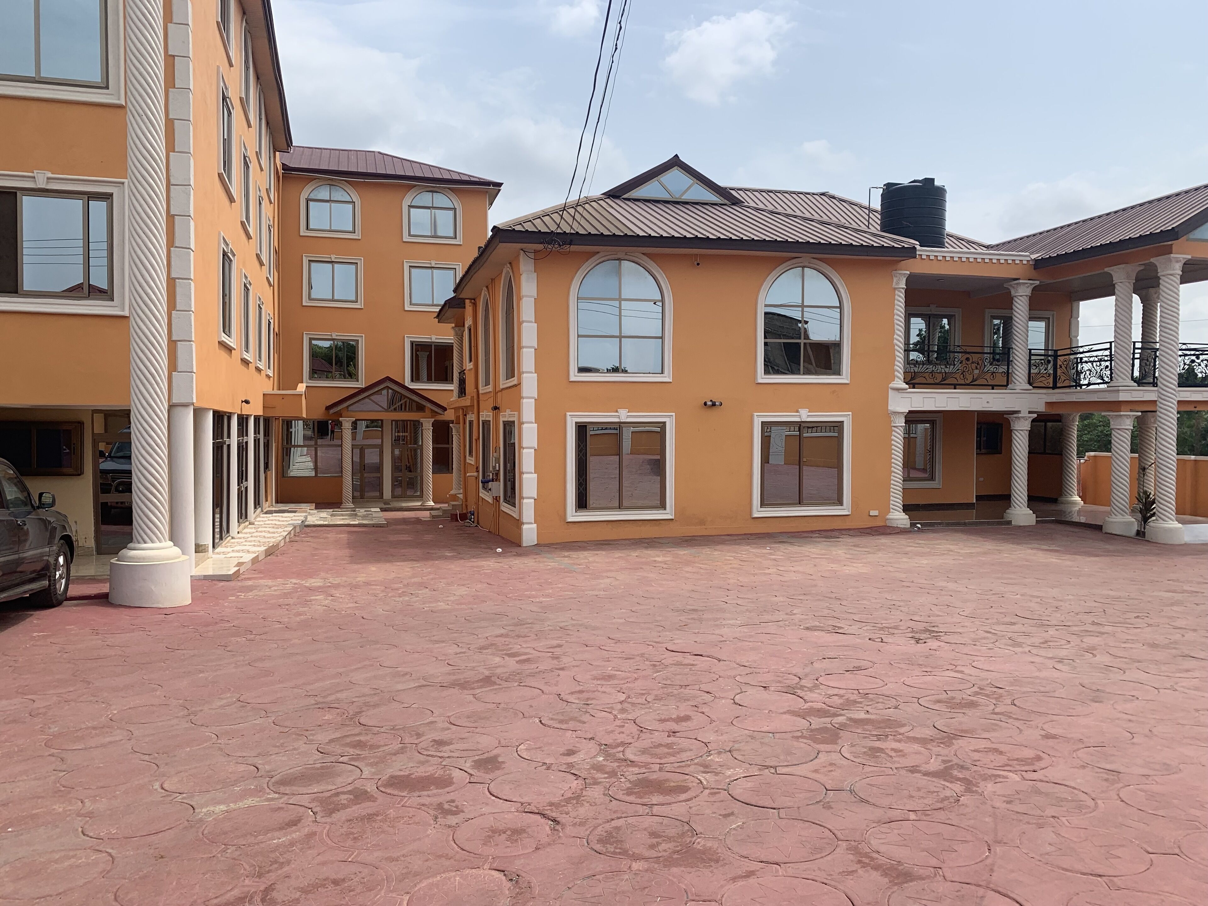 Un edificio de varios pisos con un patio central, ventanas amplias y un área de balcón techada.