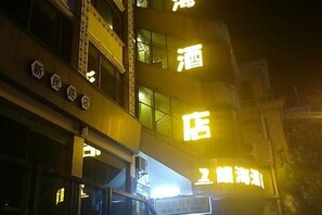 A building with illuminated signage indicating a hotel. - Yinhai Hotel (Changsha)