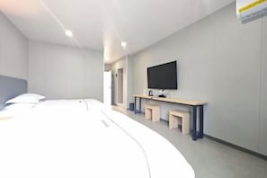 A modern hotel room with a bed, a TV, a desk, and a mirror. - Yinhai Hotel (Changsha)