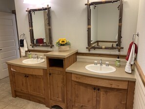 A bathroom with two sinks, wooden cabinets, and mirrors. - Double Suite, Hillside View (Kellogg)