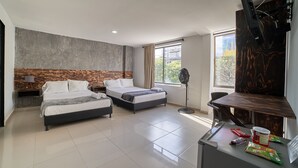 A modern hotel room with two beds, a desk, a flat-screen TV, and a large window with a city view. - Farum Hotel Medellin (Medellín)