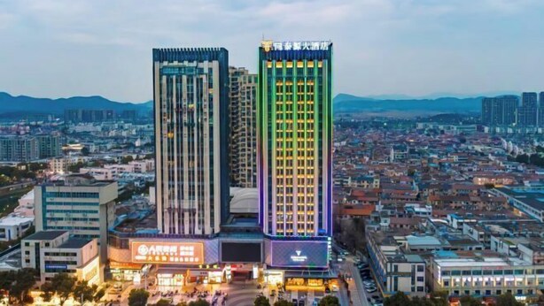 Un hôtel moderne à l’architecture verticale remarquable, doté de nombreux étages et d’une façade bien éclairée.