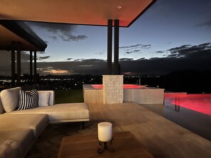 Un espace extérieur moderne aménagé avec des sièges, offrant une vue sur le paysage urbain au crépuscule.