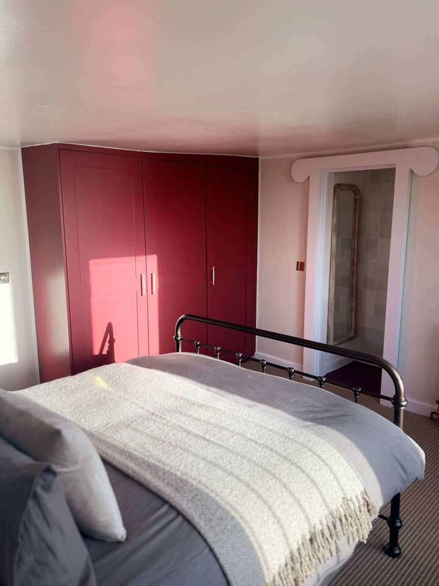 Un dormitorio con cama, armario y zona de ducha.