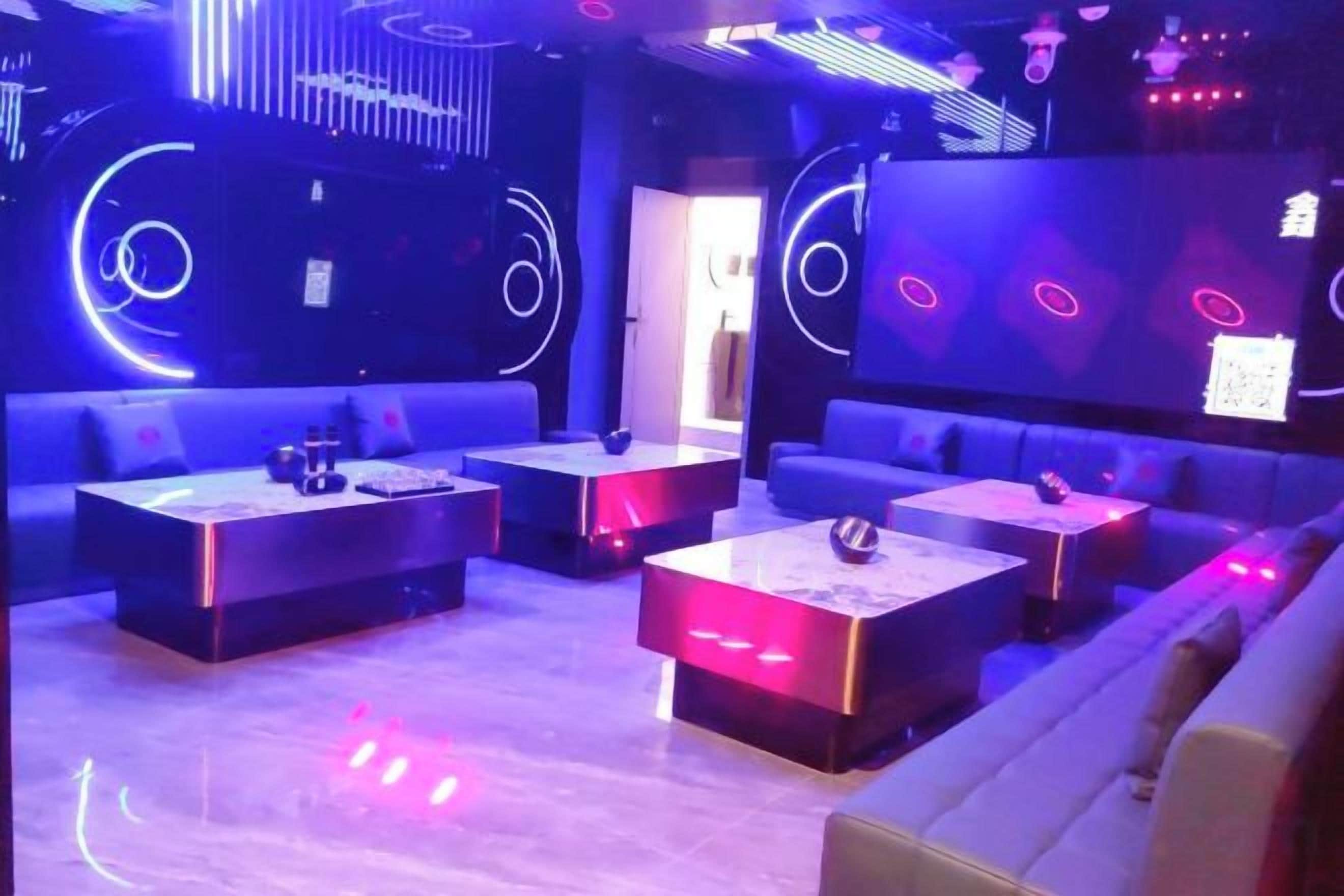 Un área de lounge moderna con sofás, mesas e iluminación ambiental.