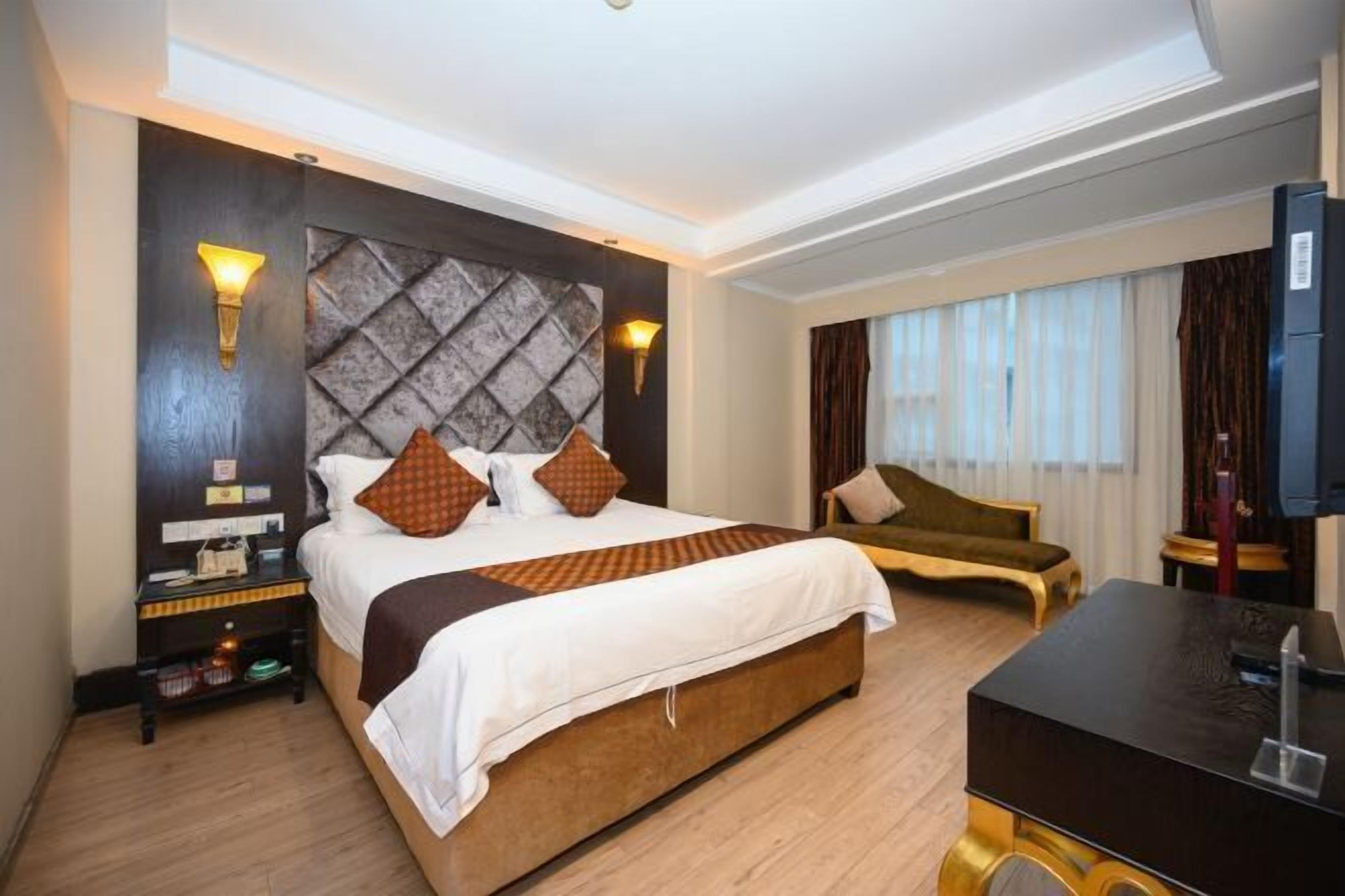 Habitación de hotel con una cama grande, un escritorio, una silla y un televisor.