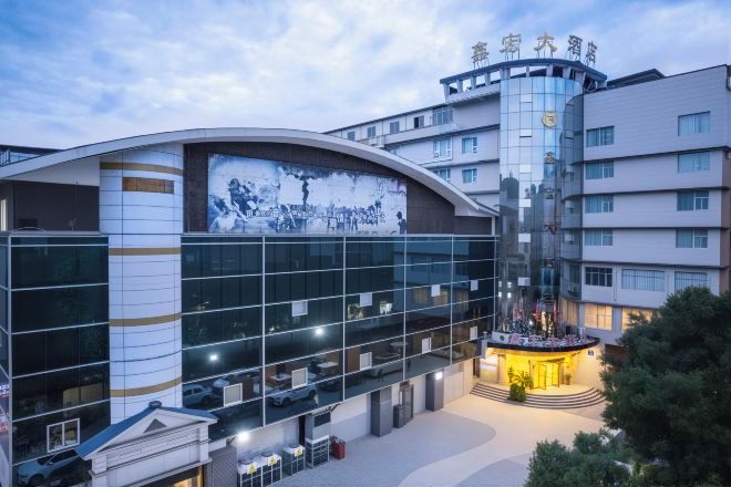 Un edificio moderno con fachada curva, amplios ventanales de vidrio y un patio central.